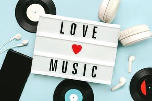 lightbox com o texto love music ao lado de fones de ouvido, smartphone e discos de vinil foto