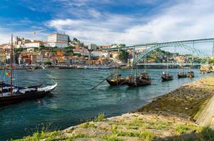 portugal, cidade paisagem porto, um grupo de barcos de madeira amarelos com barris de vinho do porto no rio douro foto