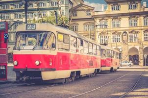 típico velho bonde retrô vintage em trilhos perto da parada de bonde nas ruas de praga foto