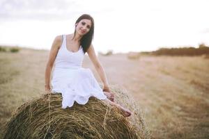 menina sorridente sentada na palha foto