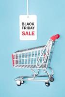 black friday.sale tag com texto e carrinho de compras. conceito de compras foto