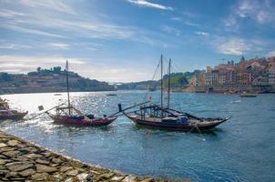 portugal, cidade paisagem porto, um grupo de barcos de madeira amarelos com barris de vinho do porto no rio douro foto