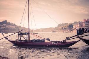 portugal, antigo visual do porto, vista panorâmica do rio douro, barco de madeira vermelha com barris de vinho do porto foto