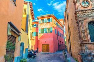 pátio italiano típico, edifícios tradicionais com paredes coloridas brilhantes e bicicletas na rua foto