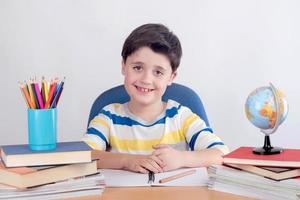 menino sorridente estudando foto