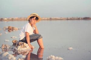 menino triste e pensativo na praia foto