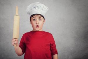 cozinheiro de criança surpreendido com um rolo foto