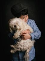 menino abraçando seu cachorro foto