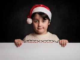 criança feliz no natal ao lado de um cartaz foto