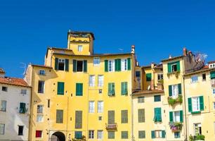 parede de edifícios coloridos com janelas de obturador na praça piazza dell anfiteatro no pátio do circo da cidade medieval de lucca foto