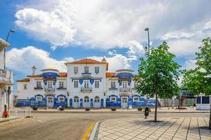 estação de aveiro, edifício da estação central de azulejos em azulejos no centro da cidade com árvores verdes foto