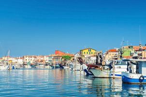 navios de pesca e barcos ancorados na lagoa do porto, perto do litoral da cidade de sottomarina foto