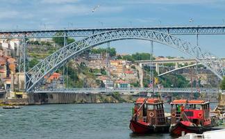 portugal, cidade paisagem porto, um grupo de barcos de madeira amarelos com barris de vinho do porto no rio douro foto