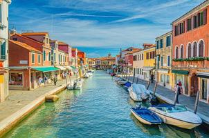 ilhas de murano com canal de água, barcos e barcos a motor, edifícios tradicionais coloridos, lagoa veneziana foto