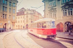 típico antigo bonde retrô vintage em trilhos perto da parada de bonde nas ruas da cidade de praga foto