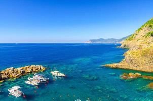 barcos de pesca ancorados na água no porto do mar da Ligúria e do Mediterrâneo, perto da costa da riviera di levante foto