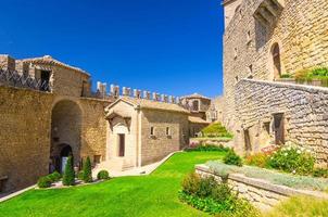 pátio com gramado de grama verde de prima torre guaita primeira torre medieval com parede de fortaleza de tijolo de pedra foto