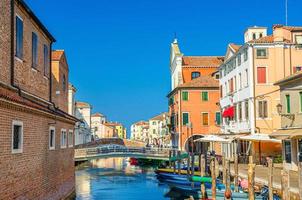 paisagem urbana de chioggia com canal de água estreito vena com barcos multicoloridos ancorados foto