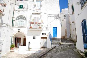 ruas estreitas da cidade de ostuni com edifícios brancos, puglia, itália foto