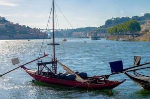 portugal, cidade paisagem porto, um grupo de barcos de madeira amarelos com barris de vinho do porto no rio douro foto