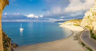 tropea cidade e praia, iate no mar Tirreno, edifícios coloridos em cima de grandes rochas altas foto