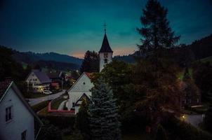 pequena aldeia bolsternang com igreja, sul da alemanha, ao pôr do sol foto