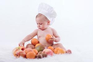 bebê engraçado com frutas foto