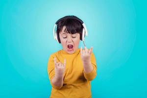 menino com fones de ouvido mostrando rock suspiro foto