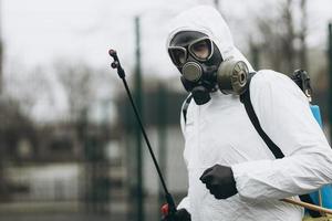 limpeza e desinfecção no complexo da cidade em meio à epidemia de coronavírus equipes profissionais para esforços de desinfecção prevenção de infecções e controle de traje e máscara de proteção epidêmica foto