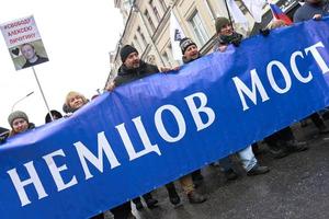 moscou, rússia - 24 de fevereiro de 2019 marcha memorial nemtsov. manifestantes carregando uma grande bandeira ponte nemtsov - requisito para as autoridades nomearem seu nome a ponte em que ele foi morto foto