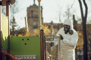 limpeza e desinfecção no playground no complexo da cidade em meio às equipes de epidemia de coronavírus para esforços de desinfecção prevenção de infecções e controle de traje de proteção e máscara epidêmica foto