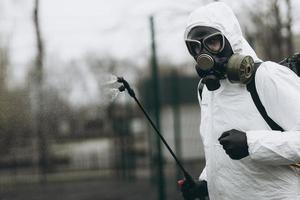 limpeza e desinfecção no complexo da cidade em meio à epidemia de coronavírus equipes profissionais para esforços de desinfecção prevenção de infecções e controle de traje e máscara de proteção epidêmica foto