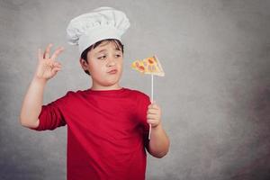 cozinheiro engraçado de criança com pizza de fatia foto