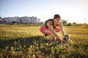 mulher jovem esportiva esticando e se preparando para correr. foto