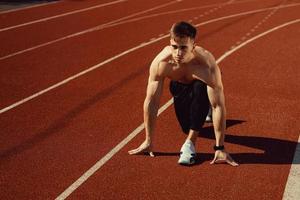 cara jovem com corpo atlético se preparando para correr foto