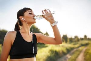 água potável de mulher jovem e desportiva foto