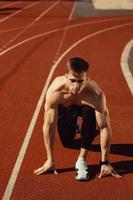 cara jovem com corpo atlético se preparando para correr foto