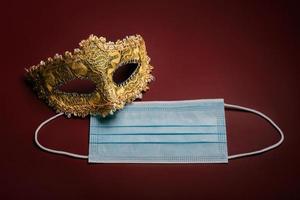 máscara de carnaval veneziano com máscara cirúrgica protetora. conceito de epidemia de coronavírus foto