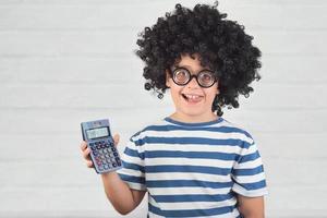 criança engraçada com calculadora usando óculos nerd foto