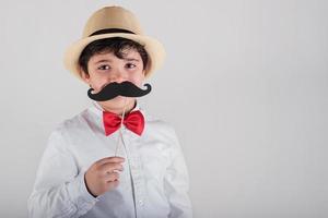 menino engraçado com bigode falso e chapéu foto