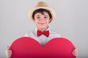 criança feliz com um coração vermelho foto