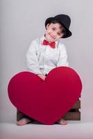 criança feliz com um coração vermelho foto