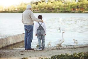 avô com seu neto no lago. vista traseira foto