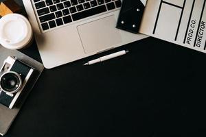 material de escritório com badalo de filme, laptop, na vista superior da mesa de madeira. foto