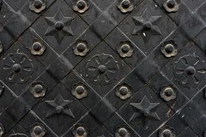 porta forjada preta, textura simétrica de losango. fundo preto grunge foto