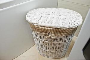 cesta de vime branca para roupas sujas no banheiro foto