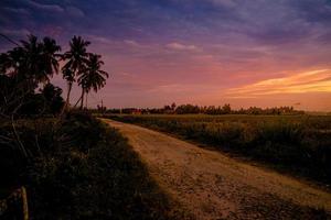 paisagem rural da vila no pôr do sol com estrada foto