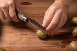 corte kiwis maduros em uma mesa de madeira. foto