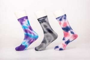 três pares de meias de diferentes cores e estilos são colocados no molde do pé em um fundo branco foto