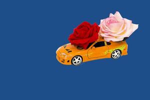 carro de brinquedo com rosas em fundo azul foto